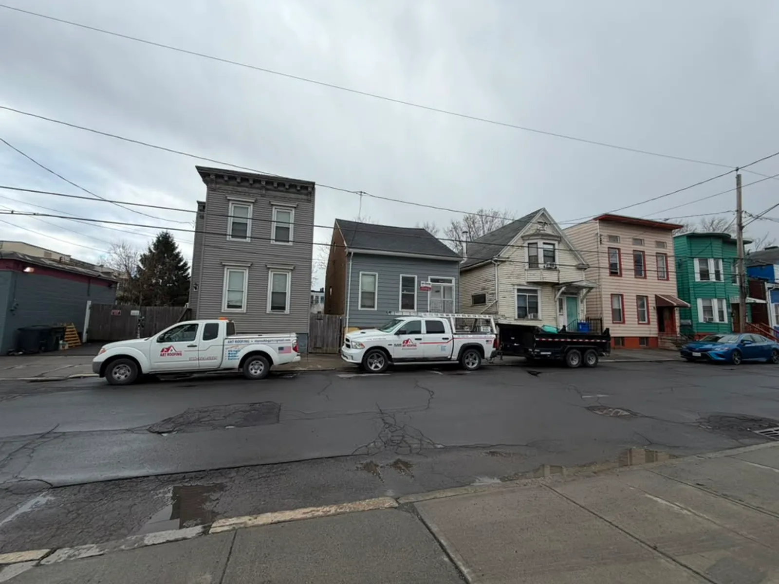 ART ROOFING trucks parked on a residential street in the Capital Region