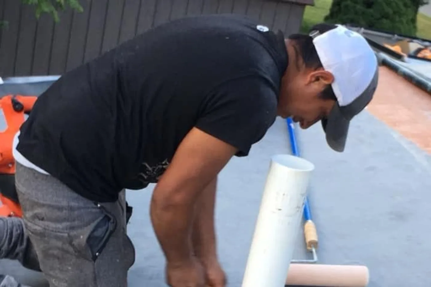 Roofer inspecting flashing and exterior trim on a house